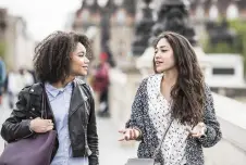Two friends walking and talking outside